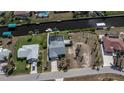 Aerial view of waterfront property, showcasing the house, pool, dock, and canal access at 129 Barre Nw Dr, Port Charlotte, FL 33952