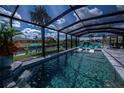 Inviting in-ground pool inside screened enclosure with comfortable lounge seating and waterfront views at 129 Barre Nw Dr, Port Charlotte, FL 33952