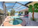 Screened-in pool area featuring both a pool and hot tub with patio space at 13049 Creekside Ln, Port Charlotte, FL 33953