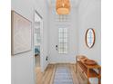 Bright foyer with light-colored walls, wood-look floors, and decorative lighting at 14724 Cherry Blossom Way, Punta Gorda, FL 33955