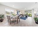 Bright open-concept living space featuring dining area, living room, and sliding door access to the outdoors at 16408 Bridle Ridge St, Port Charlotte, FL 33953
