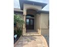 Inviting front entrance features a double door entry, arched portico and brick paver walkway at 2031 Basin St, Port Charlotte, FL 33952