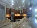 A gourmet kitchen featuring a large island, stainless steel appliances, and custom cabinets with stone backsplash at 2031 Basin St, Port Charlotte, FL 33952