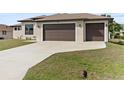 Charming single-story home featuring a spacious three-car garage and well-manicured lawn, illuminated for daytime appeal at 23218 Fawn Ave, Punta Gorda, FL 33980