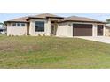 Charming single-story home featuring a spacious three-car garage and well-manicured lawn, illuminated for daytime appeal at 23218 Fawn Ave, Punta Gorda, FL 33980