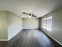 Inviting living room featuring stylish gray wood-look flooring and bright natural light from a large window at 2507 Linton Ln, Port Charlotte, FL 33952