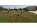 View of a home's side yard with partial fencing and greenery, offering a glimpse of the outdoor perimeter at 30035 Alder Rd, Punta Gorda, FL 33982