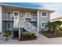 A closer exterior view shows the stairs to the second floor, with some manicured bushes at 3310 Loveland Blvd # 1808, Punta Gorda, FL 33980
