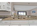 Modern kitchen with white cabinets, granite countertops, and stainless steel sink at 3627 Easy St, Port Charlotte, FL 33952
