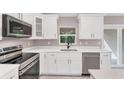 Modern kitchen featuring white cabinets, stainless steel appliances, and sleek countertops at 3841 Cinderella Rd, North Port, FL 34286