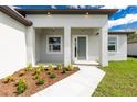 A covered porch includes manicured landscaping, a neutral color palette and a concrete walkway at 4818 Kiska Rd, North Port, FL 34288