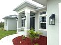 Close up view of the front entrance and meticulously manicured landscaping surrounding walkway at 9171 Waldrep St, Port Charlotte, FL 33981