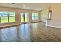 Open-concept living room with wood-look tile flooring, large windows, and recessed lighting at 9171 Waldrep St, Port Charlotte, FL 33981
