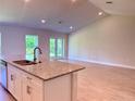 Modern kitchen features granite countertops, stainless steel sink, and an open floor plan at 9590 Little Rock St, Port Charlotte, FL 33981