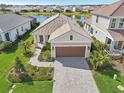 Aerial view of home featuring lush landscaping, tile roof, and lake view at 10112 Canaveral Cir, Sarasota, FL 34241