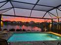 Screened in pool overlooking a beautiful lake and sunset at 10112 Canaveral Cir, Sarasota, FL 34241
