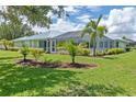 Expansive backyard featuring lush green lawn, mature palms and tropical landscaping surrounding a screened lanai at 1041 Harbour Drake Dr, Punta Gorda, FL 33983