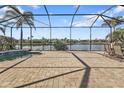 View of the lake from the expansive screened lanai featuring brick pavers, a pool, and outdoor seating at 13096 N Marsh Dr, Port Charlotte, FL 33953