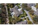 An aerial view of the house shows the layout, large driveway, landscaping, and neighborhood at 1355 Red Oak Ln, Port Charlotte, FL 33948