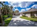 Beautiful driveway leads to a home with a large garage surrounded by tropical landscaping at 1355 Red Oak Ln, Port Charlotte, FL 33948