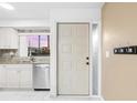 Kitchen view highlighting stainless steel appliances, granite countertops, and an access door at 1356 Rio De Janeiro Ave # 107, Punta Gorda, FL 33983