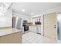 Bright kitchen featuring stainless steel appliances, granite countertops, white cabinets, and tile flooring at 1356 Rio De Janeiro Ave # 107, Punta Gorda, FL 33983