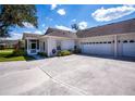 View of the side of the home showing large driveway, two-car garage, and enclosed porch at 1474 Red Oak Ln, Port Charlotte, FL 33948