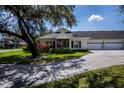 Inviting home featuring well-maintained lawn and mature trees that add to curb appeal at 1474 Red Oak Ln, Port Charlotte, FL 33948