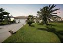 Beautiful single-story home featuring a lush green lawn and mature palm trees in a tranquil setting at 16531 San Edmundo Rd, Punta Gorda, FL 33955