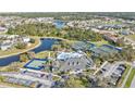 Aerial view of community with clubhouse, pool, tennis courts, lakes, and lush landscaping at 1859 Scarlett Ave, North Port, FL 34289
