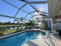 Enjoy this screened-in pool with a beautiful lake view and lush tropical landscaping at 1859 Scarlett Ave, North Port, FL 34289