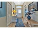 Bright entryway with a decorative rug, console table, and chandelier, leading into the home at 1944 Boddington Trl, Port Charlotte, FL 33980