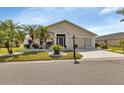 Charming single-story home featuring a well-manicured lawn with a bench and beautiful plants at 1944 Boddington Trl, Port Charlotte, FL 33980