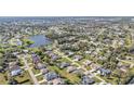 A picturesque aerial view of a community featuring lush greenery, a tranquil lake, and well-maintained homes at 206 Santarem Cir, Punta Gorda, FL 33983
