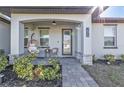 Inviting front porch with cozy seating, decorative plants, and a charming entrance to the home at 206 Santarem Cir, Punta Gorda, FL 33983