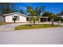 Cozy single-story home with a carport, circular driveway, and verdant palm trees at 2521 Clipper Ship Way, Sarasota, FL 34231