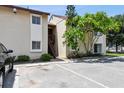 Condo exterior featuring stairs to the units, parking, and green landscaping with a mature tree at 2717 Hidden Lake Blvd # C, Sarasota, FL 34237