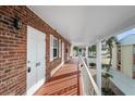 Second-story exterior hallway with brick walls, white trim, and secure, numbered entry doors at 380 Base E Ave # 202, Venice, FL 34285