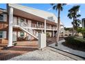 Two-story brick exterior featuring white trim and stairs, leading to charming unit entrances at 380 Base E Ave # 202, Venice, FL 34285