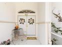 Charming covered front porch with double doors, a welcome sign and a decorative metal chair at 3816 N Cranberry Blvd, North Port, FL 34286