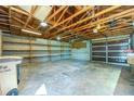 Spacious detached garage interior features concrete floors, exposed rafters, and shelving along the back wall at 434 W Grace St, Punta Gorda, FL 33950