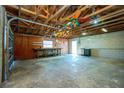 A view into detached garage featuring concrete floors, exposed rafters, and wooden workbench along the back wall at 434 W Grace St, Punta Gorda, FL 33950