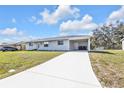 Single-story home with a long driveway and covered parking area, offering ample space and convenience at 5211 Prime Ter, North Port, FL 34286