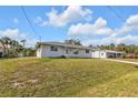 Cozy single-story home with a well-maintained lawn, surrounded by lush greenery, creating a serene environment at 5211 Prime Ter, North Port, FL 34286