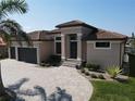 Stunning home featuring a three-car garage, lush landscaping, and a tile roof, perfect for luxurious living at 556 Monaco Dr, Punta Gorda, FL 33950