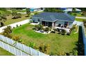 Large, fenced backyard featuring a patio, vibrant greenery, and plenty of space to enjoy at 7243 Patricia Pl, Englewood, FL 34224