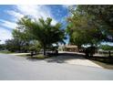 Peaceful suburban street view featuring a well-maintained home with mature trees and landscaping at 825 Robinhood Dr, Punta Gorda, FL 33982