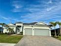 Beautiful one-story home with a large driveway and a well-kept lawn, complemented by palm trees and an attached garage at 15155 Scarlet Oak Ct, Punta Gorda, FL 33955