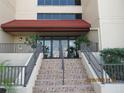 Entrance to the building with stairs and a tiled landing and railing at 21405 Olean Blvd # 605, Port Charlotte, FL 33952