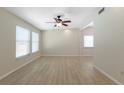 Spacious living room featuring sleek wood floors, bright windows, and a modern ceiling fan at 2255 Easy St, Port Charlotte, FL 33952